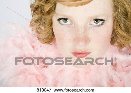 Stock Photo - Portrait of a young woman wearing a pink feather boa. Fotosearch