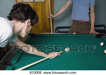Stock Photo - Two young men playing pool. Fotosearch