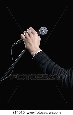 Detail of a man holding a microphone View Large Photo Image Stock Image - Detail of a man holding a microphone. Fotosearch