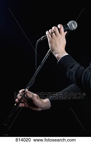 Detail of a man holding a microphone View Large Photo Image Stock Image - Detail of a man holding a microphone. Fotosearch