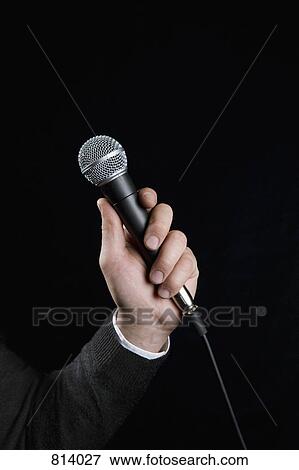 Detail of a man holding a microphone View Large Photo Image Stock Photo - Detail of a man holding a microphone. Fotosearch