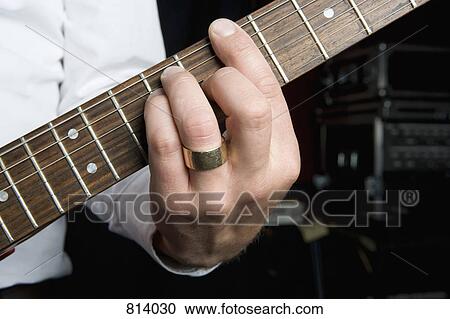 Stock Image - Detail of a man playing an electric guitar. Fotosearch