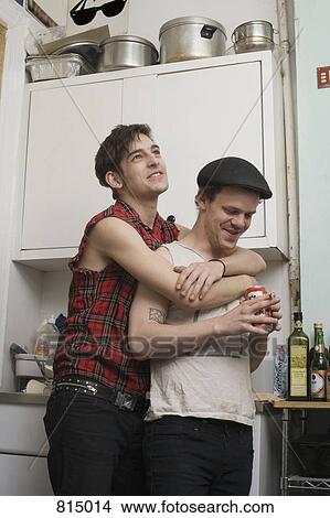 Picture - A young couple standing together in a kitchen. Fotosearch