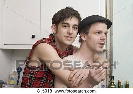 Stock Photo - A young couple standing together in a kitchen. Fotosearch