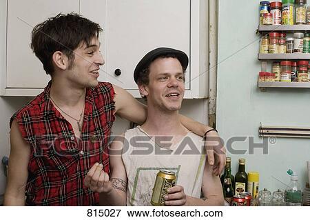 A young couple standing together in a kitchen View Large Photo Image Stock Photo - A young couple standing together in a kitchen. Fotosearch
