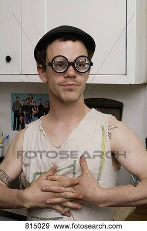 A young man standing in a kitchen wearing silly glasses View Large Photo Image Stock Photo - A young man standing in a kitchen wearing silly glasses. Fotosearch
