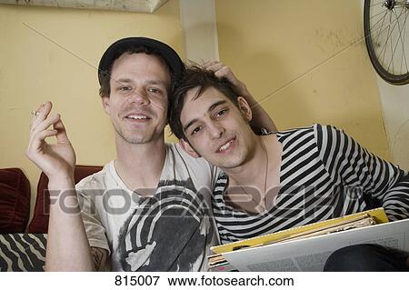 Stock Photo - Portrait of a young couple sitting together on a sofa. Fotosearch