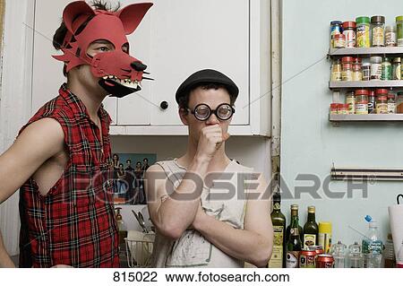 Two young men standing in a kitchen wearing silly disguises View Large Photo Image Stock Image - Two young men standing in a kitchen wearing silly disguises. Fotosearch