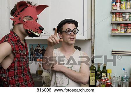 Two young men standing in a kitchen wearing silly disguises View Large Photo Image Stock Photograph - Two young men standing in a kitchen wearing silly disguises. Fotosearch