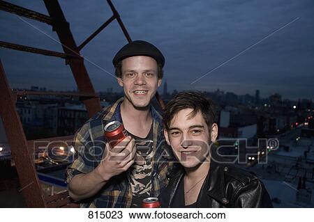 Two young men standing on a fire escape at night View Large Photo Image Stock Image - Two young men standing on a fire escape at night. Fotosearch