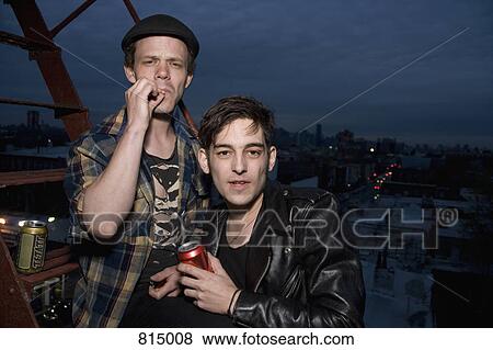 Two young men standing on a fire escape at night View Large Photo Image Stock Photo - Two young men standing on a fire escape at night. Fotosearch