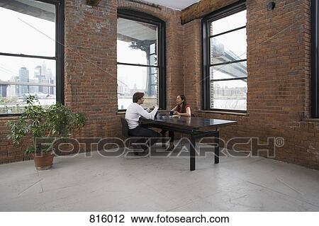 Stock Image - A couple sitting at a table together. Fotosearch