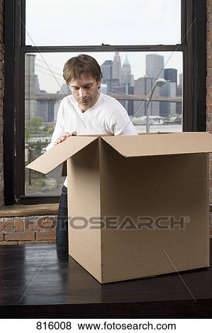 A man packing a cardboard box View Large Photo Image Stock Photo - A man packing a cardboard box. Fotosearch