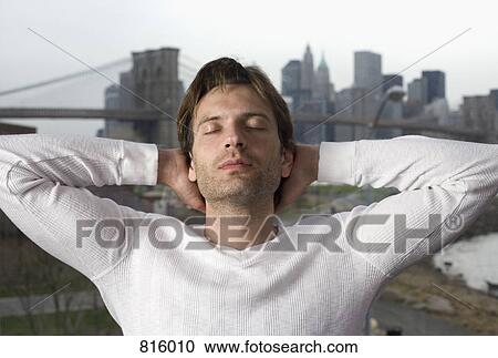 A man relaxing with his hands behind his head View Large Photo Image Stock Image - A man relaxing with his hands behind his head. Fotosearch