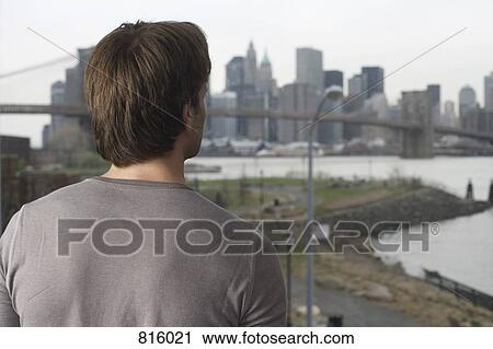 Man looking through window at Manhattan skyline View Large Photo Image Stock Image - Man looking through window at Manhattan skyline. Fotosearch