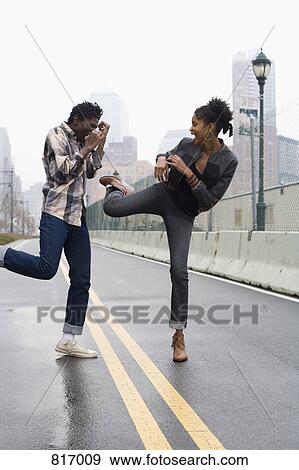 A man and a woman standing on a street and play fighting View Large Photo Image Stock Photo - A man and a woman standing on a street and play fighting. Fotosearch