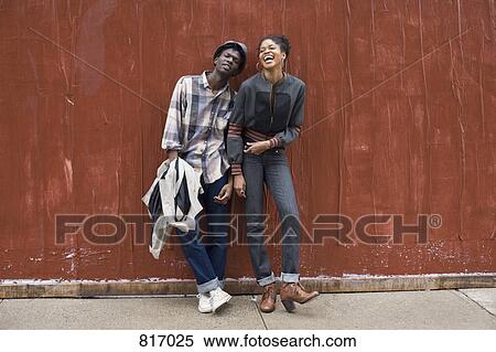 A young couple leaning against a wall View Large Photo Image Stock Photography - A young couple leaning against a wall. Fotosearch