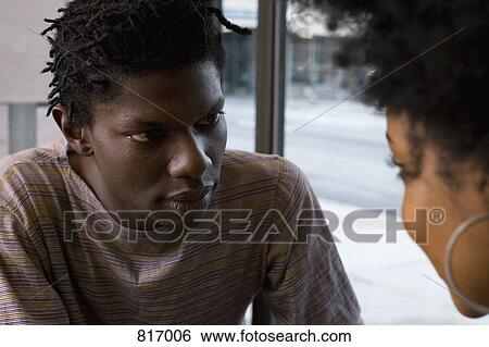 A young couple sitting face to face View Large Photo Image Stock Photograph - A young couple sitting face to face. Fotosearch