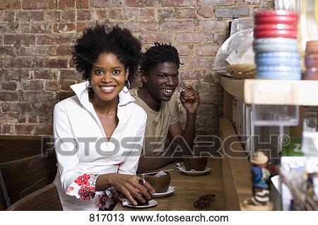 A young couple sitting in a cafe together View Large Photo Image Stock Image - A young couple sitting in a cafe together. Fotosearch