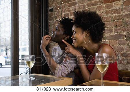 A young couple sitting in a restaurant with glasses of white wine View Large Photo Image Stock Image - A young couple sitting in a restaurant with glasses of white wine. Fotosearch