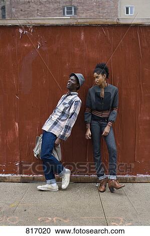 A young couple standing on a sidewalk View Large Photo Image Stock Image - A young couple standing on a sidewalk. Fotosearch