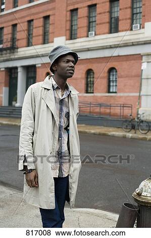 A young man standing on a sidewalk View Large Photo Image Stock Photo - A young man standing on a sidewalk. Fotosearch