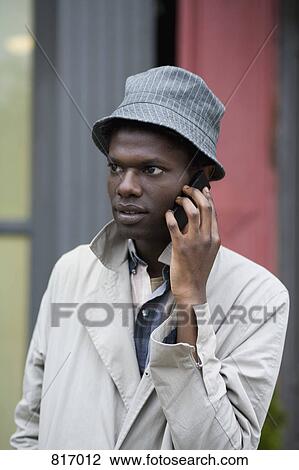 Stock Image - A young man using a mobile phone. Fotosearch