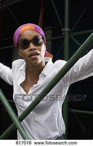 Portrait of a young woman wearing sunglasses and a headscarf View Large Photo Image Stock Photograph - Portrait of a young woman wearing sunglasses and a headscarf. Fotosearch