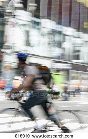 Stock Image - A cyclist on a city street, Manhattan, New York City. Fotosearch