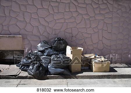 Stock Image - Boxes and bags of rubbish on a sidewalk. Fotosearch