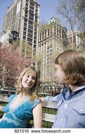 A young couple sitting on a park bench together, Central Park, New York City View Large Photo Image Stock Photograph - A young couple sitting on a park bench together, Central Park, New York City. Fotosearch