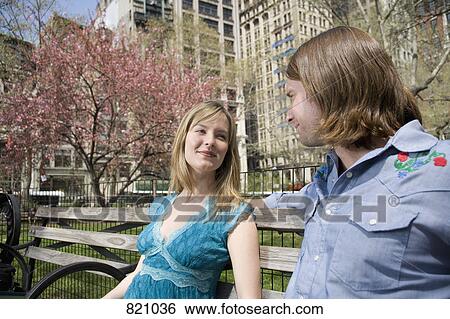 A young couple sitting on a park bench together, Central Park, New York City View Large Photo Image Stock Photograph - A young couple sitting on a park bench together, Central Park, New York City. Fotosearch