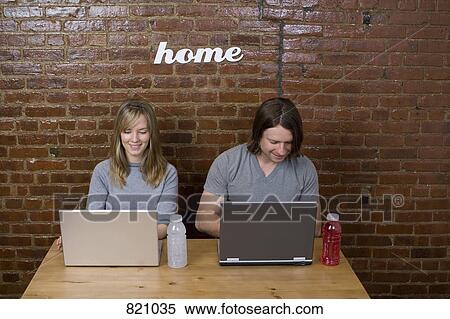 A young couple using laptops side by side View Large Photo Image Stock Photography - A young couple using laptops side by side. Fotosearch