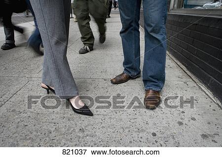 Low section of a man and a woman standing on a sidewalk, New York City View Large Photo Image Stock Photo - Low section of a man and a woman standing on a sidewalk, New York City. Fotosearch