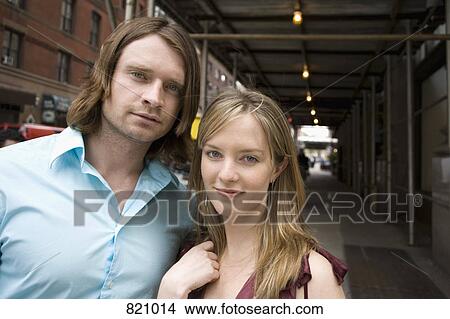 Portrait of a young couple standing on a city street View Large Photo Image Picture - Portrait of a young couple standing on a city street. Fotosearch