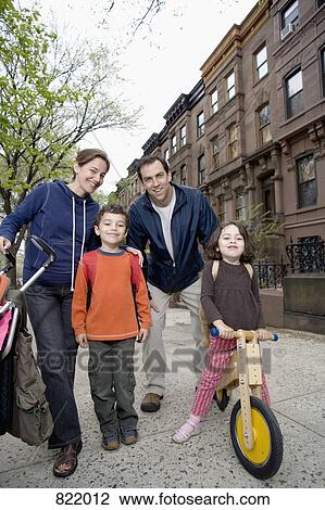 Stock Image - A family standing together on a sidewalk, Brooklyn, New York City. Fotosearch