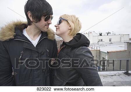 A young couple about to kiss on a rooftop holding hands View Large Photo Image Stock Image - A young couple about to kiss on a rooftop holding hands. Fotosearch