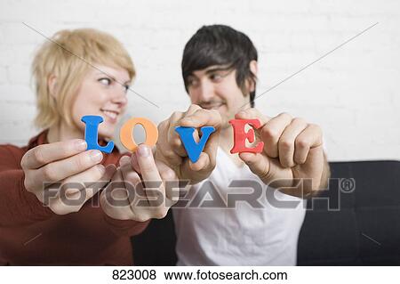A young couple holding plastic letters that spell the word love View Large Photo Image Stock Photo - A young couple holding plastic letters that spell the word love. Fotosearch