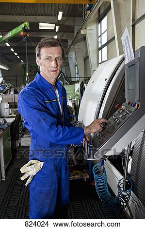 A man operating a machine in a factory View Large Photo Image Picture - A man operating a machine in a factory. Fotosearch