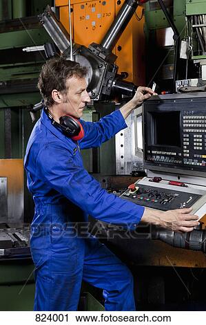 A man operating a machine in a metal parts factory View Large Photo Image Stock Image - A man operating a machine in a metal parts factory. Fotosearch