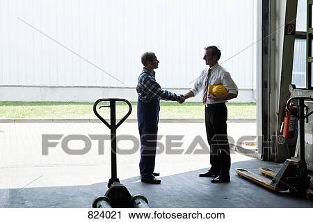 A manual worker shaking hands with a manager in a metal parts warehouse View Large Photo Image Stock Image - A manual worker shaking hands with a manager in a metal parts warehouse. Fotosearch