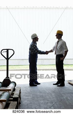 A manual worker shaking hands with a manager in a metal parts warehouse View Large Photo Image Stock Photograph - A manual worker shaking hands with a manager in a metal parts warehouse. Fotosearch