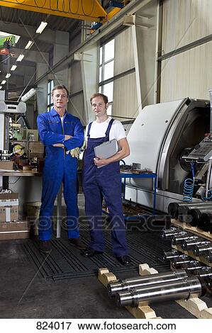 Portrait of two manual workers in a metal parts factory View Large Photo Image Stock Photo - Portrait of two manual workers in a metal parts factory. Fotosearch