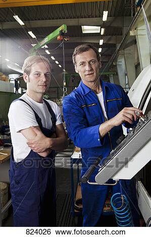 Two manual workers in a metal parts factory View Large Photo Image Stock Photograph - Two manual workers in a metal parts factory. Fotosearch