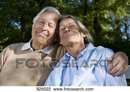 Stock Image - A senior couple sitting on a bench together. Fotosearch