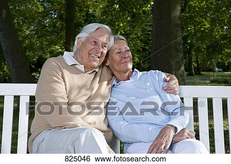 A senior couple sitting on a bench together View Large Photo Image Stock Photograph - A senior couple sitting on a bench together. Fotosearch