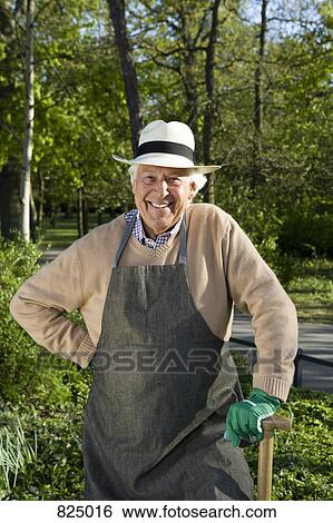 A senior man dressed for gardening taking a break View Large Photo Image Stock Photograph - A senior man dressed for gardening taking a break. Fotosearch