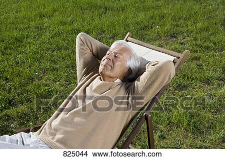 A senior man reclining in a lounge chair on a lawn View Large Photo Image Picture - A senior man reclining in a lounge chair on a lawn. Fotosearch