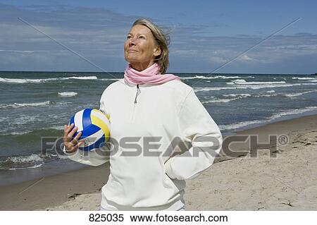 Stock Photography - A senior woman holding a soccer ball. Fotosearch