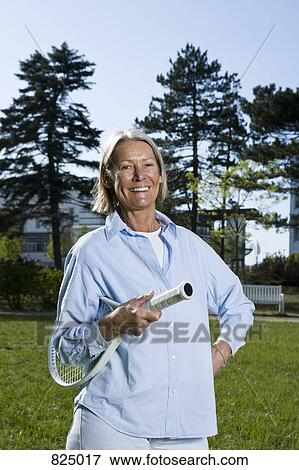 A senior woman holding a tennis racket View Large Photo Image Stock Photo - A senior woman holding a tennis racket. Fotosearch